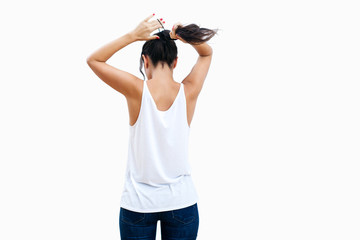 Wall Mural - Back view of slender brunette woman putting her hair up in ponytail