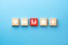 Insurance Concept. Wooden Blocks With Insurance Icons. Family, Life, Car, Travel, Health And House Insurance Icons. Blue Background With Copy Space