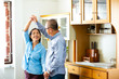 © NVB Stocker - Asian senior couple is dancing and smiling while cooking together in kitchen