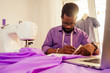 © yurakrasil - happy male african designer constructor engineer writing down ideas in a notebook in studio