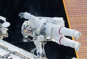 Wall Mural - the astronaut in a space suit, in the iss, lasts a hand in the camera. elements of this image were f
