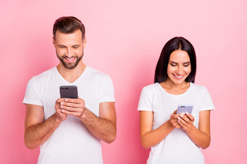 Wall Mural - Portrait of his he her she two nice-looking attractive lovely charming focused cheerful cheery spouses using app 5g browsing internet online isolated over pink pastel background