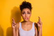 Close up photo beautiful she her dark skin model lady look up empty space not smiling asking win winner victory lottery good best result fingers crossed wear casual tank-top isolated yellow background