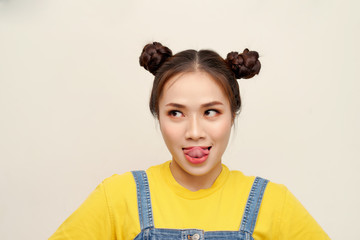 Beautiful young Asian girl wearing jeans dungaree with two buns hair on white background