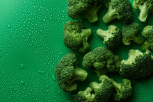 Fresh Raw Broccoli On Green Background With Copy Space, Top View. The Concept Of Healthy Food, Diet, Sulforaphane, Cruciferous Vegetables