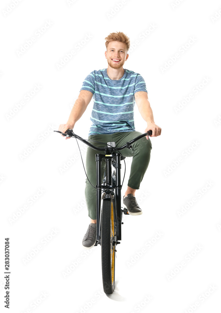 Young man riding bicycle against white background