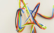 Electric wires of different colors in curved form on a gray background