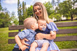 © Louis-Paul Photo - Happy mother having fun with his two son baby on the park