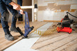 © Louis-Photo - A Male Worker install wood floor on a house