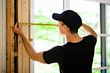 © Louis-Paul Photo - A handsome young man installing Double Sliding Patio Door in a new house construction site