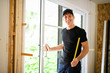 © Louis-Paul Photo - A handsome young man installing Double Sliding Patio Door in a new house construction site