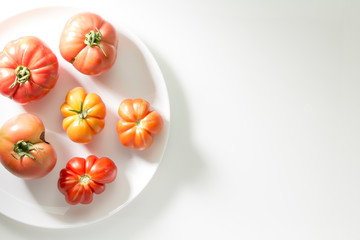 Ugly freak organic tomato on a white background. The concept of organic vegetables. The view from the top. Space for text.