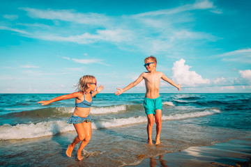 Poster - happy cute boy and girl play on beach