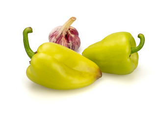 Two green sweet peppers of green color. Head of young garlic. On a white background, isolated. Close-up. Still life.