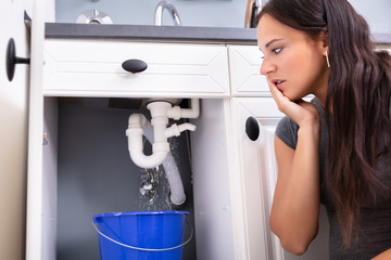 Woman With Leakage Problem In Kitchen