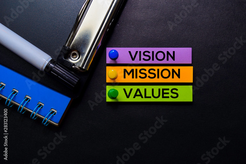 Vision, Mission, Values text on sticky notes isolated on Black desk. Mechanism Strategy Concept