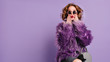 canvas print picture - Spectacular young woman with trendy makeup posing with surprised face expression on bright purple background. Indoor photo of shocked female model in stylish fur jacket.