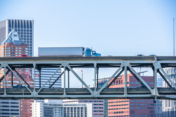 Big rig semi truck transporting goods in refrigerator semi trailer running on the bridge in Portland down town