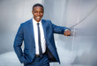 © elnariz - Stylish modern african american business man, handsome smiling portrait next to financial building