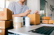 © wutzkoh - Asian young teenager owener of small business packing product in boxes preparing it for delivery.