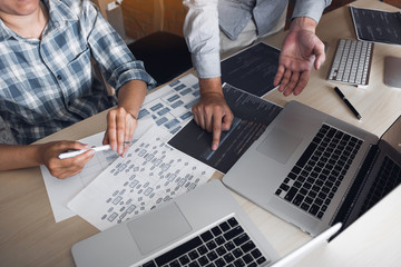 Two software developers are analyzing together about the code written into the program on the computer.