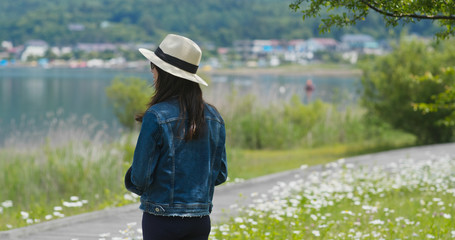 Sticker - Woman look around the landscape and sit on the wooden bench