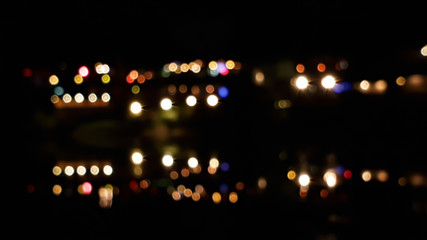 Wall Mural - Blurred and bokeh of city lighting with reflection on water in night time background