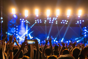 Concert crowd of Music fanclub hand using cellphone taking video record or Live stream with superstar songer, happy new year, christmas and festival concept