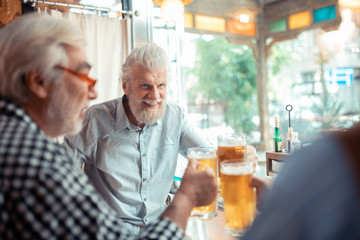 Man smiling while drinking beer with friends