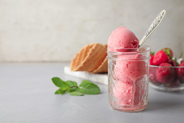 Delicious pink ice cream served in jar on grey table. Space for text