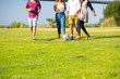 © Mangostar - Cropped shot of friends kicking ball in park. Young people having fun together. Leisure concept