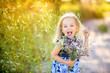 © Tortuga - playful cute little girl playing outdoors at sunset, holding a bouquet of wildflowers and having fun, happy childhood