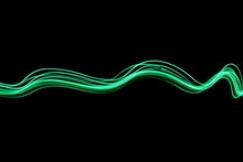 Long Exposure, Light Painting Photography.  Vibrant Abstract Streaks Of Neon Green Color Against A Black Background.