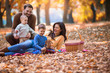 © Mediteraneo - Happy family of four having fun together in the park in autumn