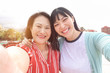 © DisobeyArt - Happy asian mother and daughter taking selfie photo for postin on social network - Family people having fun with technology trends - Love and summer concept - Focus on faces