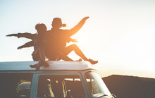 Happy Couple Silhouette Sitting On Top Of Minivan At Sunset - Young People Having Fun On Summer Vacation Traveling Around The World - Travel, Love, Van Lifestyle, Concept - Focus On Bodies