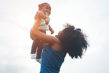 Happy African Mother Playing With Her Daughter Outdoor - Afro Mum And Child Having Fun Together - Family, Happiness And Love Concept - Soft Focus On Woman Face