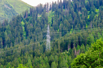 Wall Mural - Power line with large steel pylons in alpine valley in Switzerland.