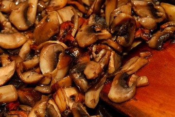 Poster - Fried champignon mushrooms in a pan closeup background texture