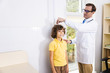 © Yakobchuk Olena - Smiling doctor fixing boy height stock photo