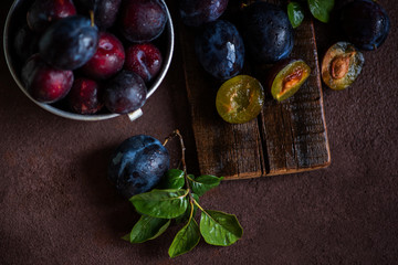 Wall Mural - Colander with ripe juicy plums on table.