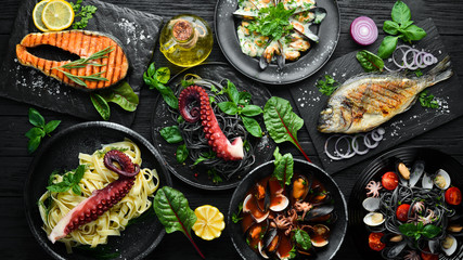 Sticker - Set of Seafood Dishes. Seafood on a plate. On a black wooden background. Top view. Free copy space.