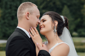 Wall Mural - Happy young bride and groom on their wedding day. Wedding couple - new family. Sweet kiss of bride and groom at wedding day. Wedding dress. 