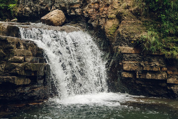 Wall Mural - small waterfall with a lake among rocks and forest