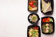 Healthy food delivery in black boxes to go on white