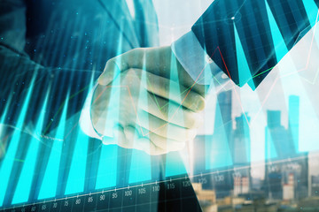 Double exposure of financial graph on cityscape background with two businessman handshake. Concept of stock market deal