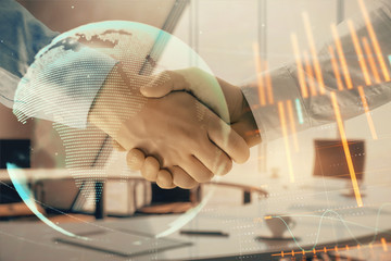 Multi exposure of financial chart and map on office background with two businessmen handshake. Concept of success in business