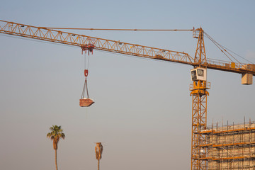 construction crane lifting cargo with clear blue sky background