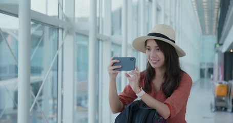 Wall Mural - Woman take photo on cellphone in the airport