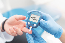 Doctor Checking Blood Sugar Level With Glucometer